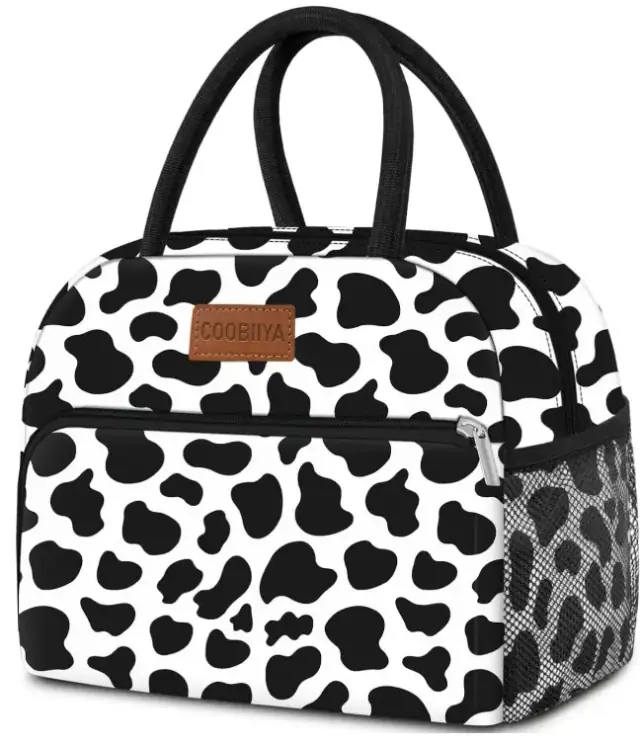 Coobiiya lunch tote with a black-and-white cow print, black handles and a side mesh pocket